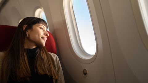 Woman looking out of a plane window