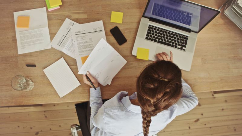 mujer-de-negocios-trabajando-en-su-oficina-escritorio-con-documentos-y-laptop