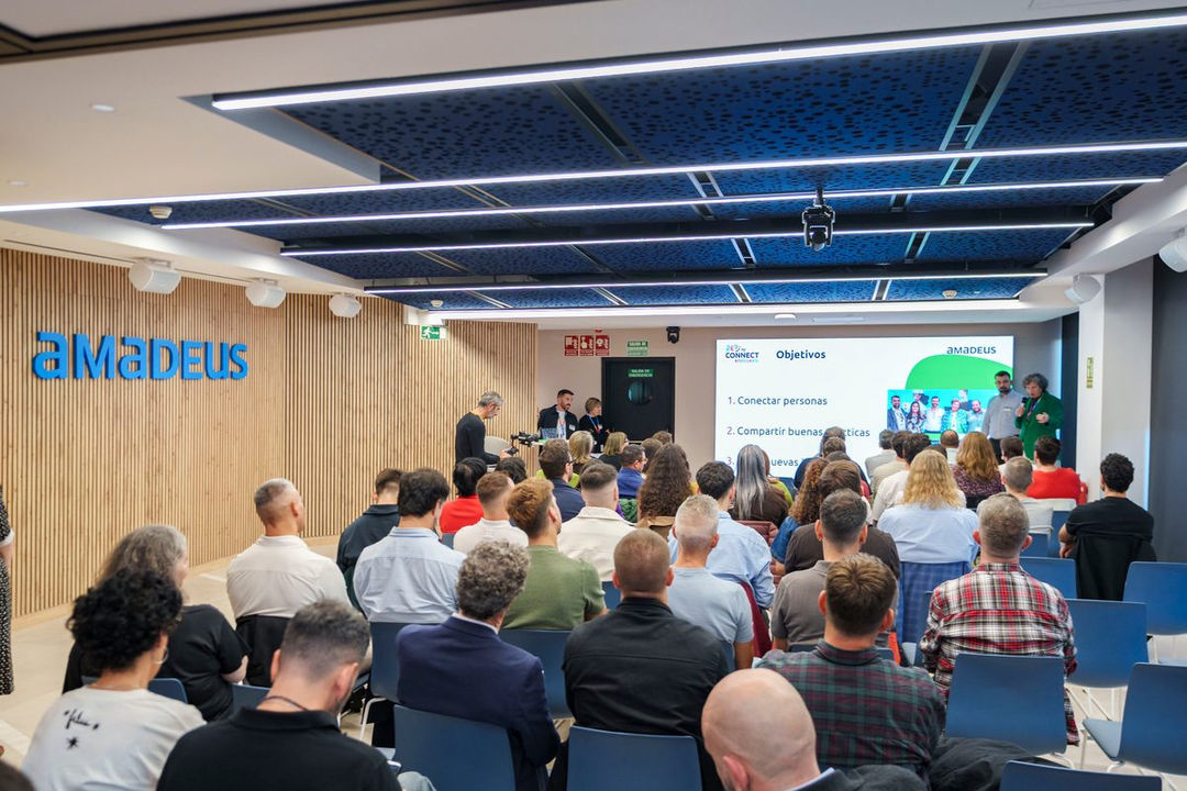 RTCE attendees seated in rows for a group photo at the Amadeus office, with the Amadeus logo visible on the wall.