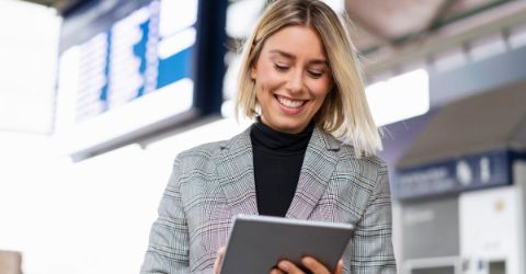Business woman looking at tablet in an airport