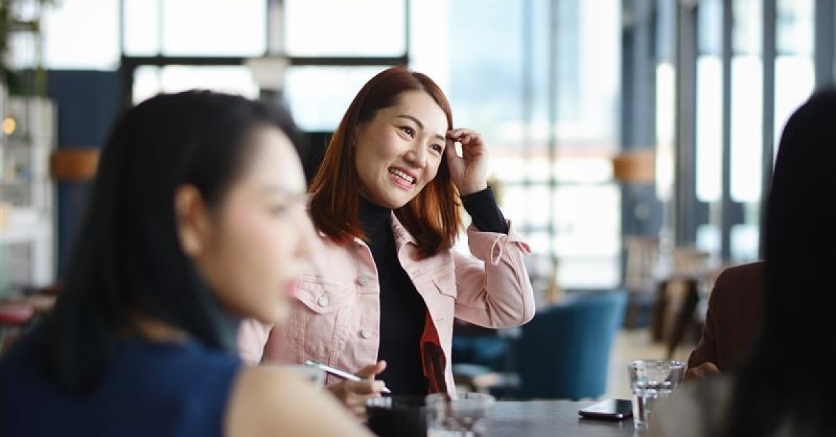 Three women in a lobby having a business meeting