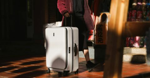 Unrecognisable woman with white suitcase