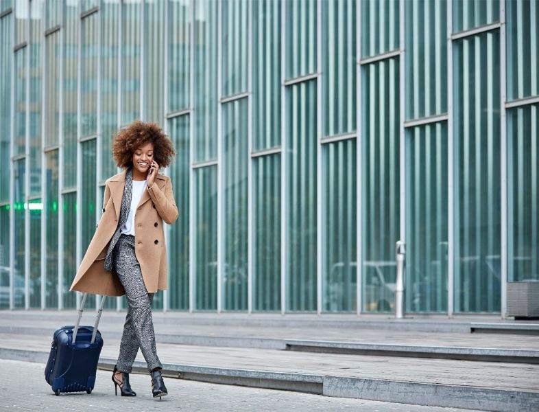 businesswoman-with-luggage-talking-on-smartphone