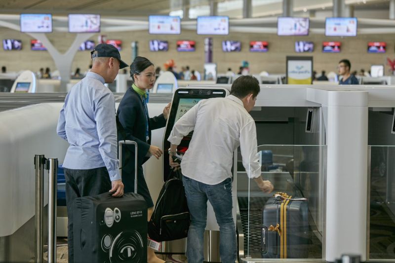Passengers at an airport using a Series 7 Auto Bag Drop.