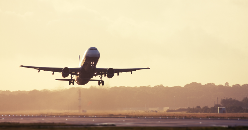 Aircraft taking off at sunrise