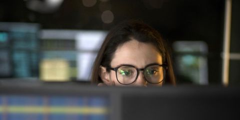 A data scientist looks at her computer screen