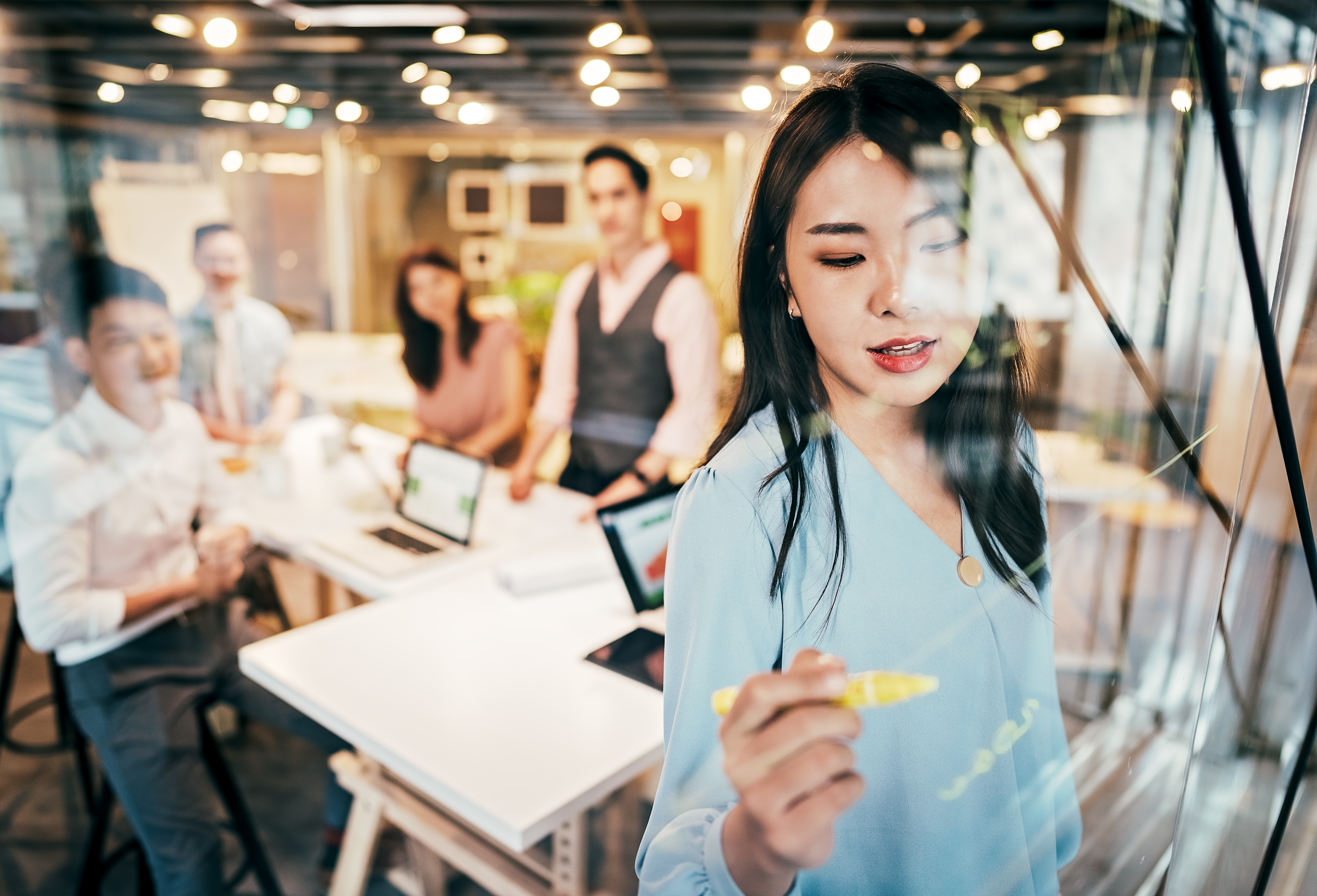 A group of men and women in an office brainstorm ideas for an innovative product.