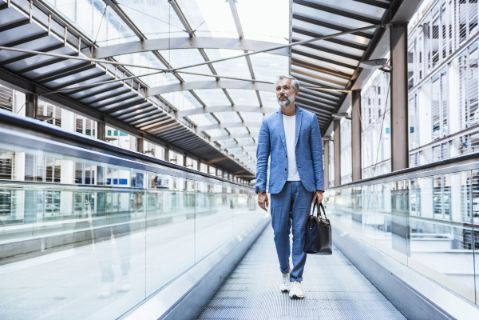 Man in suit walking with a briefcase in a station