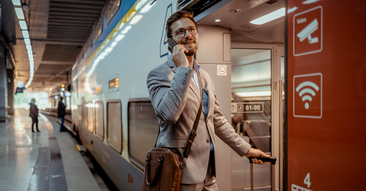 Man talking on the phone to an AI agent in a train station